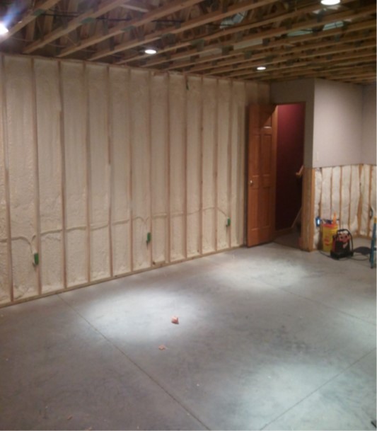 Agricultural building roof being coated by a spray applicator